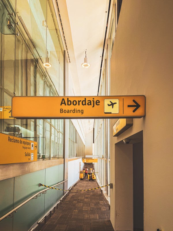 An airport boarding sign with a directional arrow.
