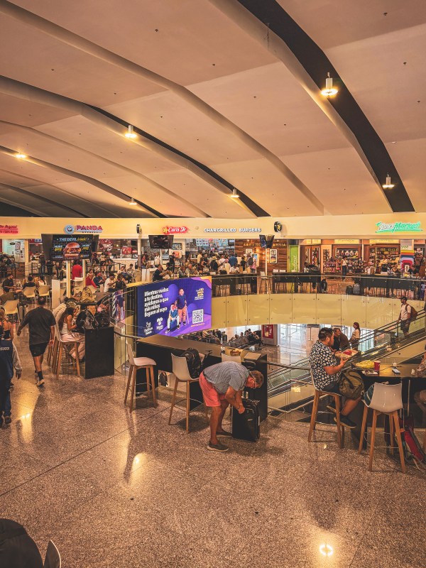 Travellers dining in an airport food court.