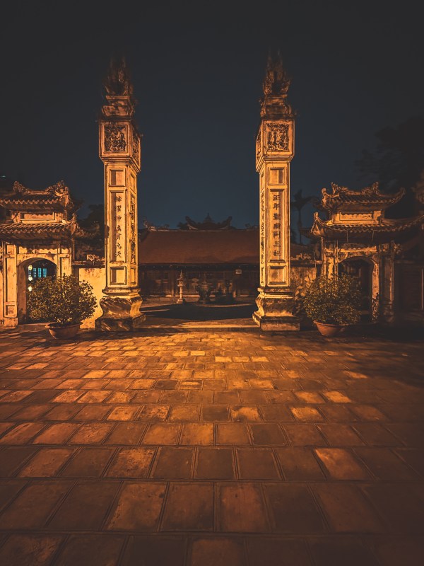 A gateway lit at night in Hanoi.