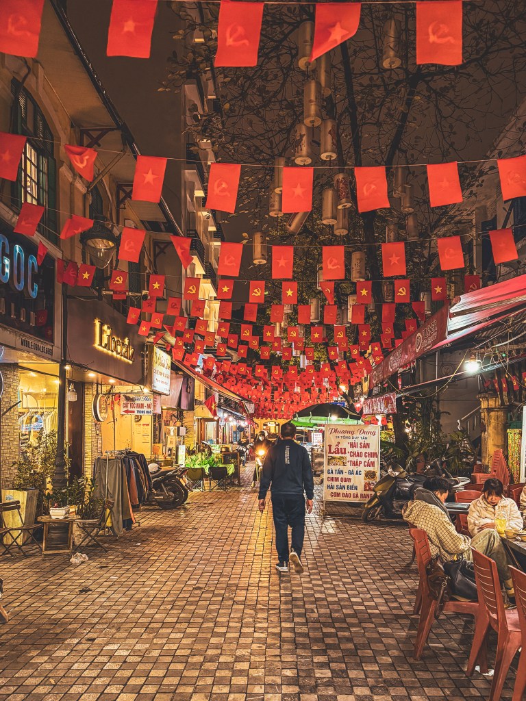 A narrow Hanoi street decorated with colourful bunting.