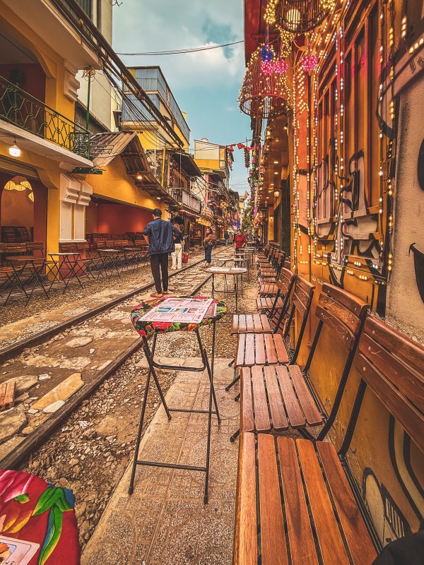Chairs and shopfronts beside a railway line in Hanoi.