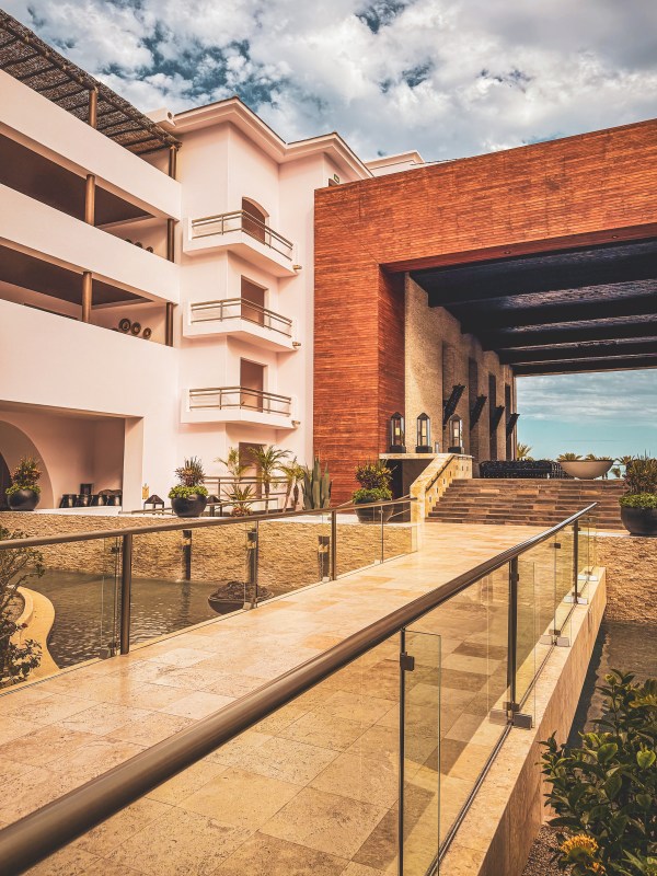A walkway beside resort buildings and a covered entrance.
