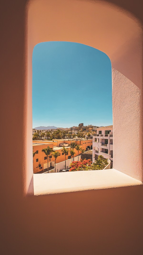 A view of buildings through an arched opening at a property.