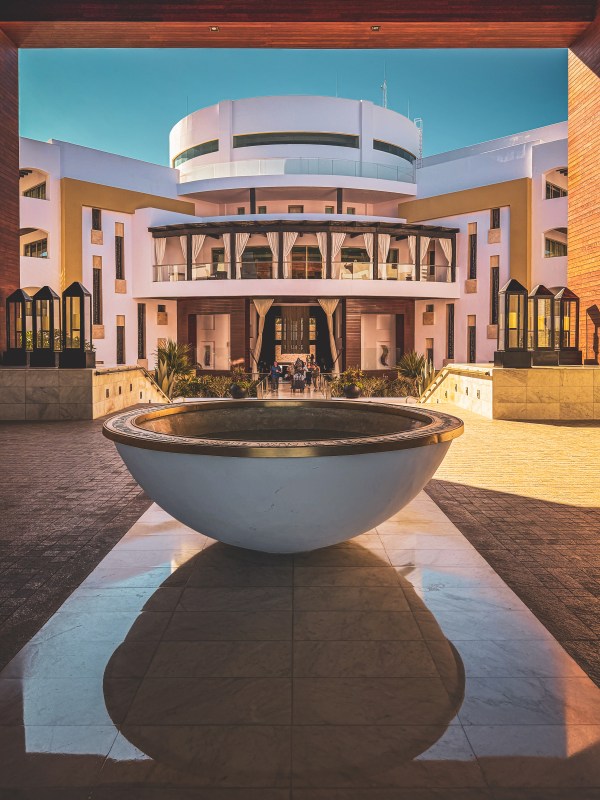 Hotel courtyard with fountain and symmetrical entrance.