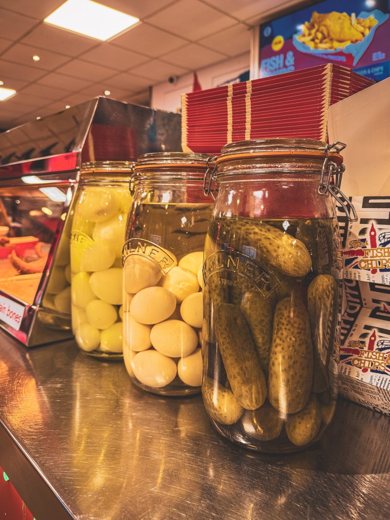 Jars of pickled onions, eggs and gherkins on a London fish-and-chip shop counter.