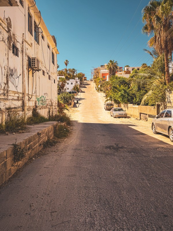 A sunlit pedestrian lane between buildings in Los Cabos.
