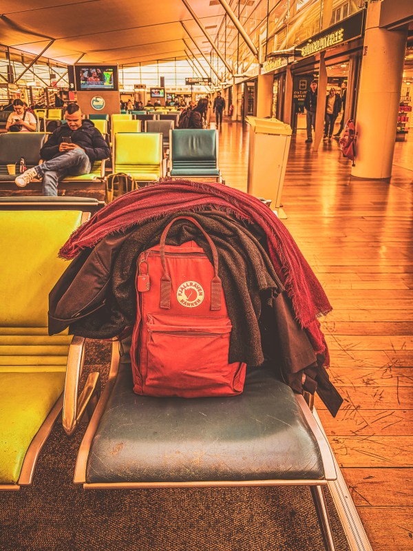 Backpacks on a luggage trolley in a terminal.