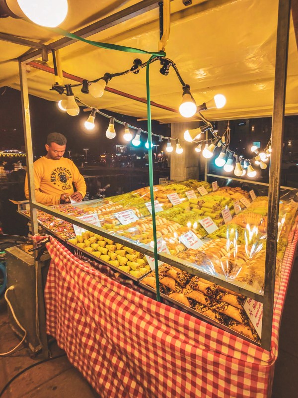 A warmly lit outdoor food stall with display counters in Malta.