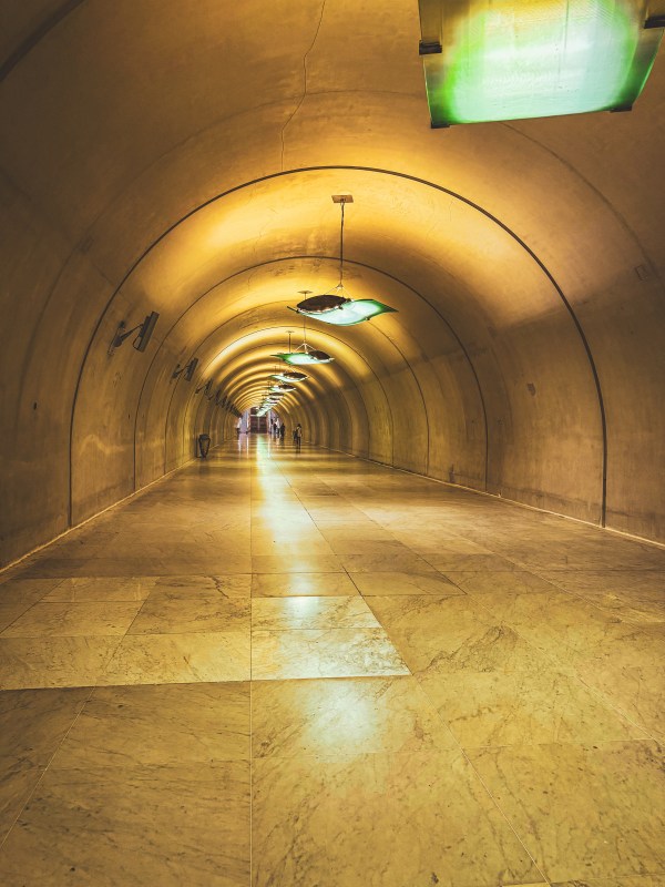 A softly lit arched underground corridor in Paris.