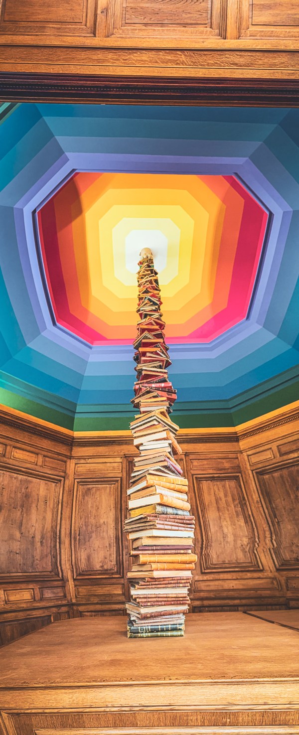 A colourful geometric installation rising through a Paris interior.