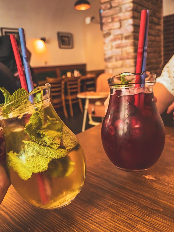 Two colourful drinks on a table inside a Prague venue.