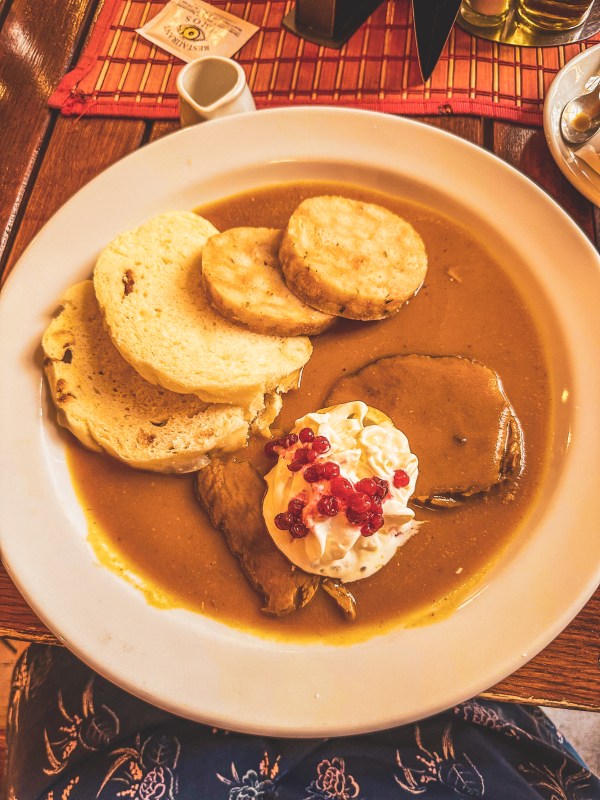 A plated meal with sliced dumplings and sauce in Prague.