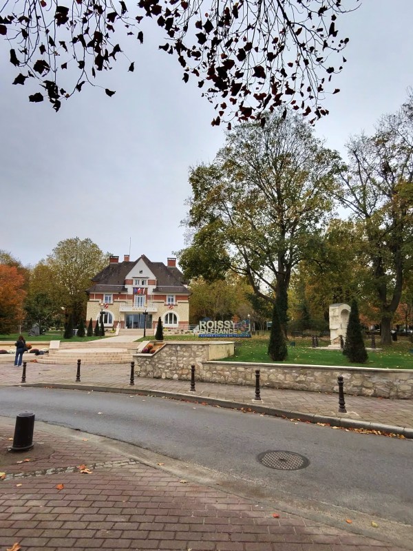 A building across the road framed by trees in Roissy-en-France.