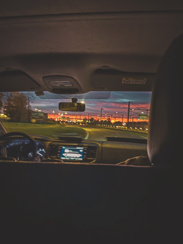The view through a vehicle windscreen approaching a lit airport area near Roissy-en-France.