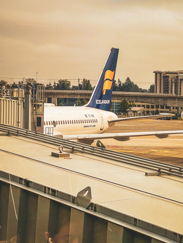 Aircraft parked beside an airport terminal.