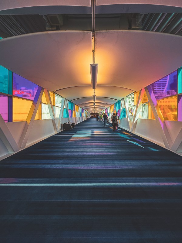 Colourful illuminated corridor leading toward an interior display.