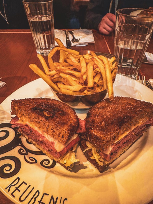 Toasted sandwich and fries served at a restaurant table.
