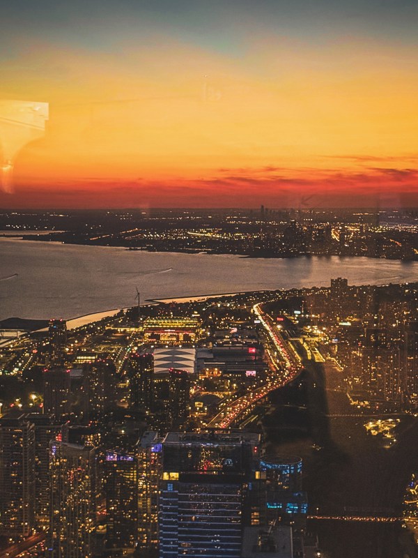 City skyline and waterfront beneath a golden sunset.