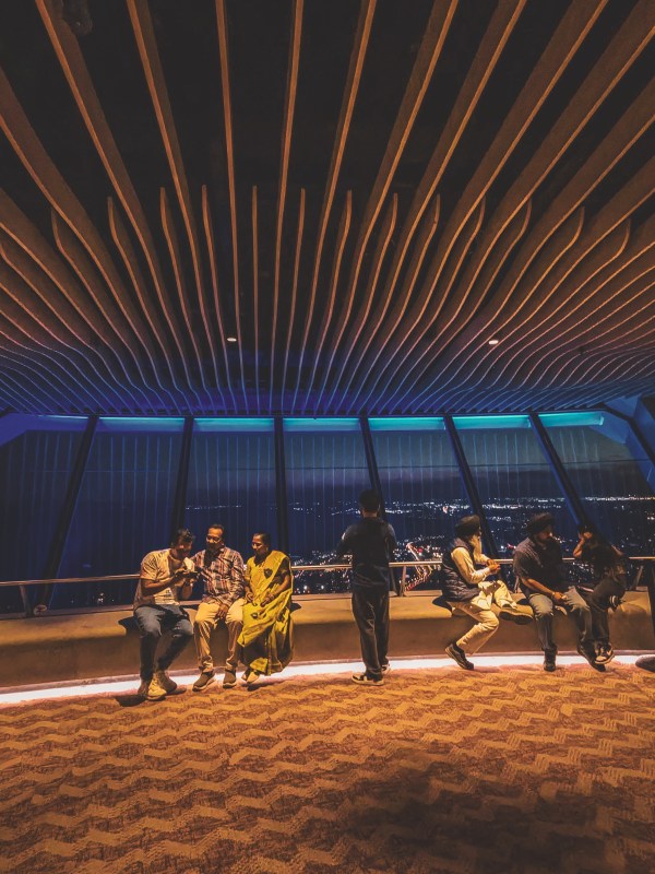 Visitors seated beneath a dramatic slatted ceiling.