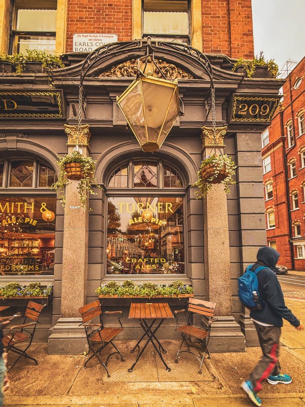 Decorated pub exterior with flowers and outdoor tables.