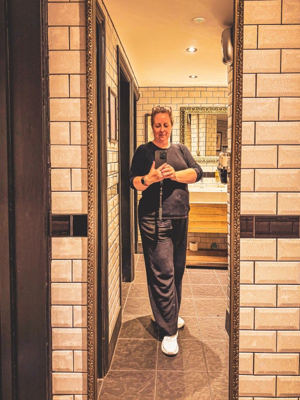 Staff member standing in a tiled London doorway.