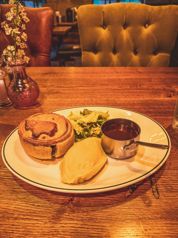 Pie, vegetables and gravy on a London restaurant table.