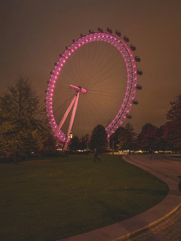 London Eye illuminated pink at night.
