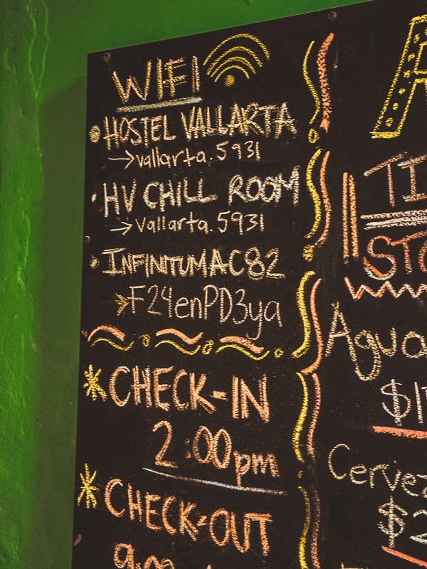 Chalkboard displaying Wi-Fi and hostel check-in information.